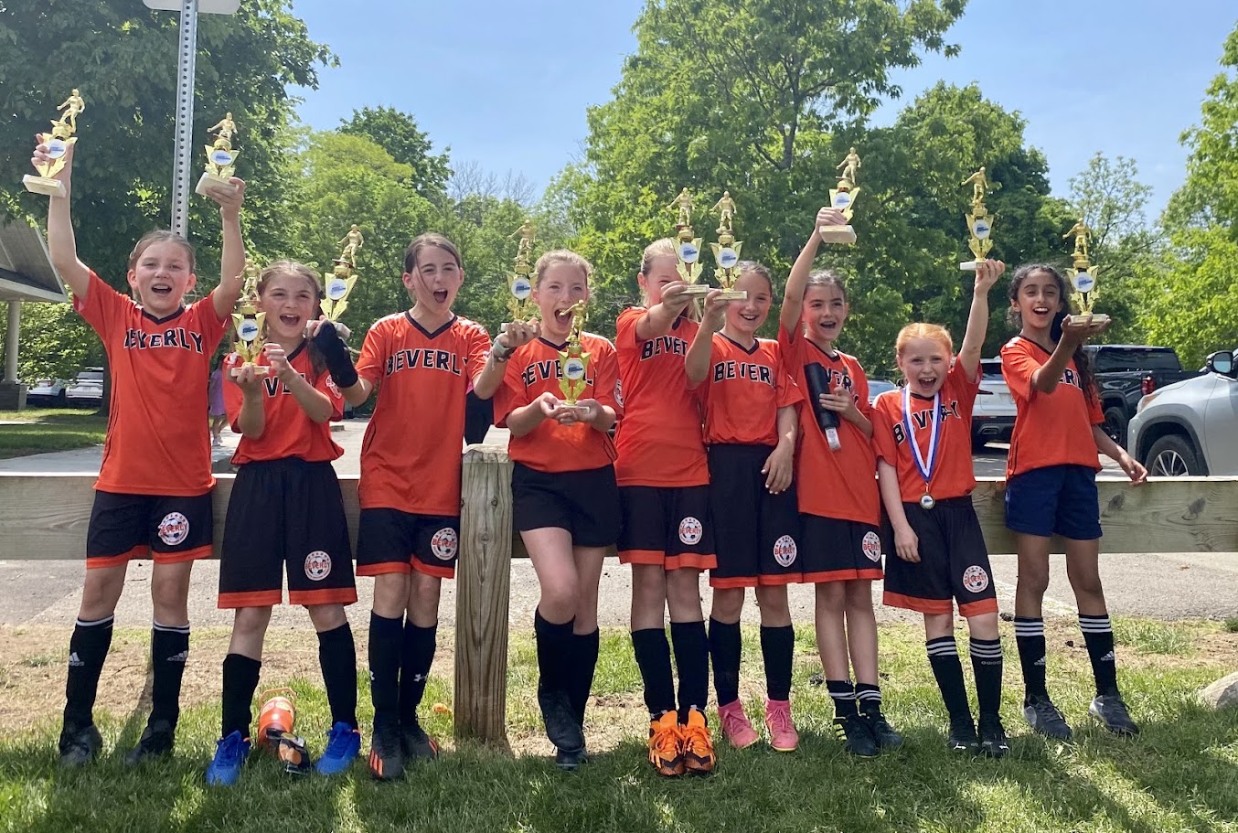 Beverly Youth Soccer players celebrating with trophies
